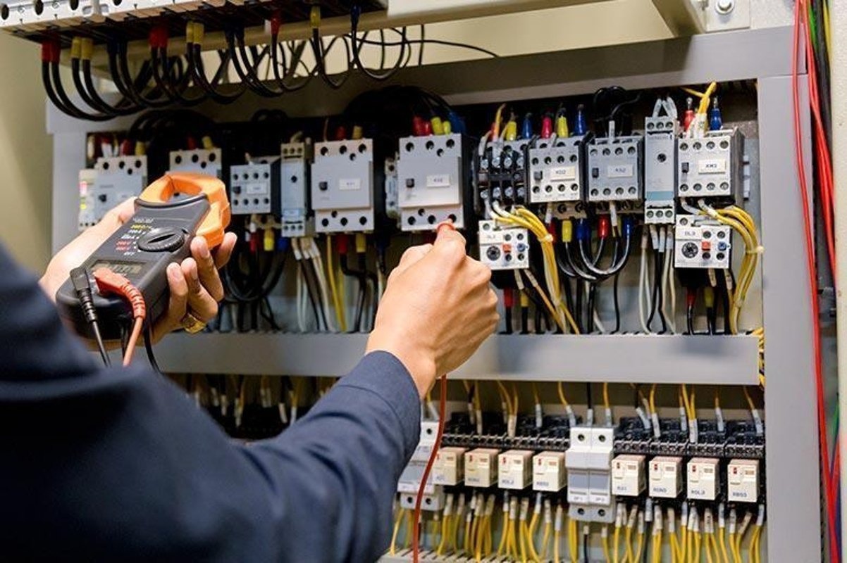 Technician testing an electrical control panel